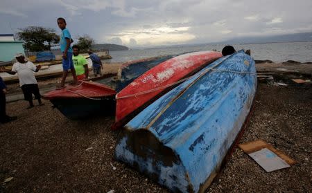 Boats which are secured are seen near residents at Port Royal while Hurricane Matthew approaches, in Kingston, Jamaica October 2, 2016. REUTERS/Henry Romero