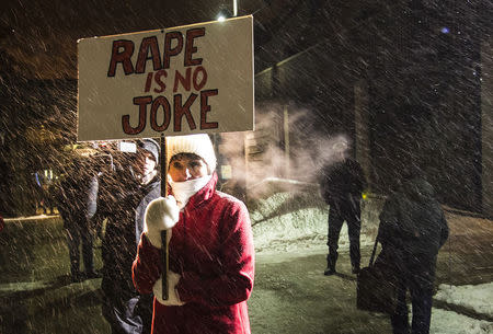A woman holding a sign that reads "Rape is No Joke" protests as people walk into the Centre In The Square venue where Bill Cosby is performing in Kitchener, January 7, 2015. REUTERS/Mark Blinch