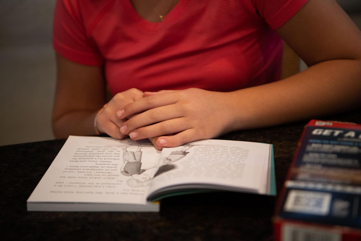 Myleigh Eason, 11, reads a book while at the kitchen table at her home in Spring Hill, Tenn., Monday, April 15, 2024.