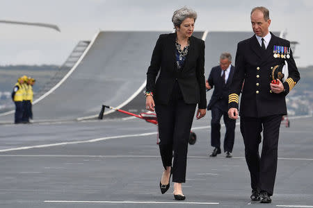 Britain's Prime Minister Theresa May talks with Commodore Jerry Kyd, Captain of the British aircraft carrier HMS Queen Elizabeth, during her tour of the ship, after it arrived at Portsmouth Naval base, its new home port, in Portsmouth, Britain August 16, 2017. REUTERS/Ben Stansall