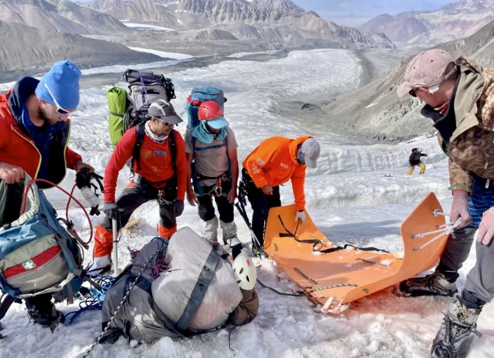 Transferring the casualty from makeshift stretcher to SKED at the fixed ropes and ladders. 