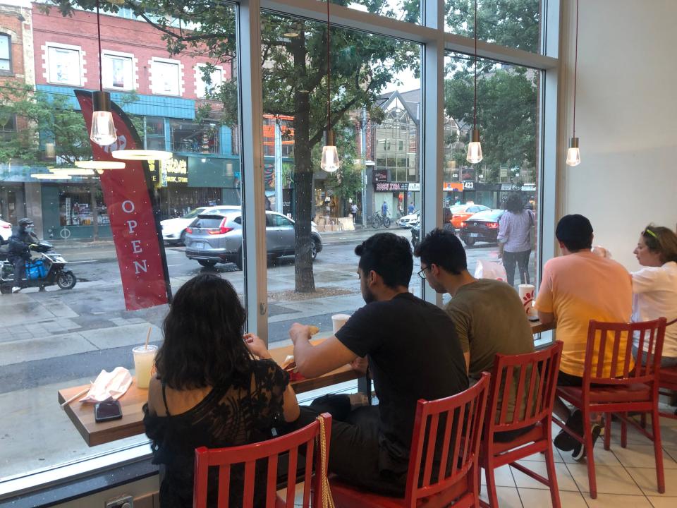 diners sitting at the window counter at a chil fil a in toronto