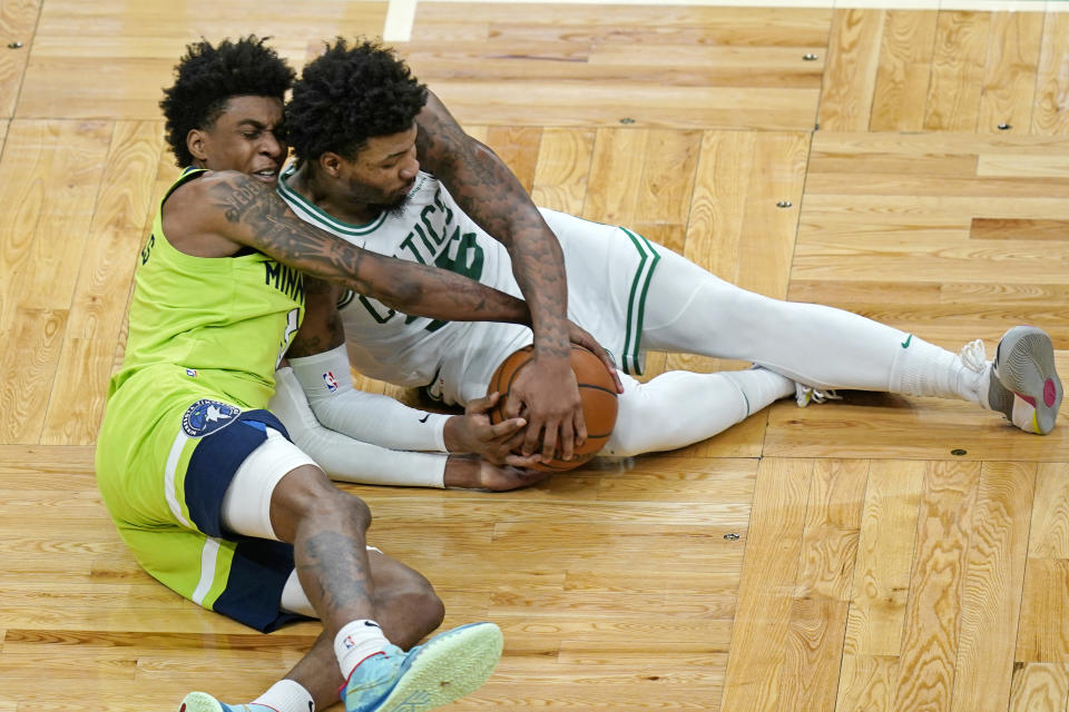Minnesota Timberwolves forward Jaden McDaniels, left, and Boston Celtics guard Marcus Smart (36) compete for the ball on the floor in the second half of an NBA basketball game, Friday, April 9, 2021, in Boston. (AP Photo/Elise Amendola)