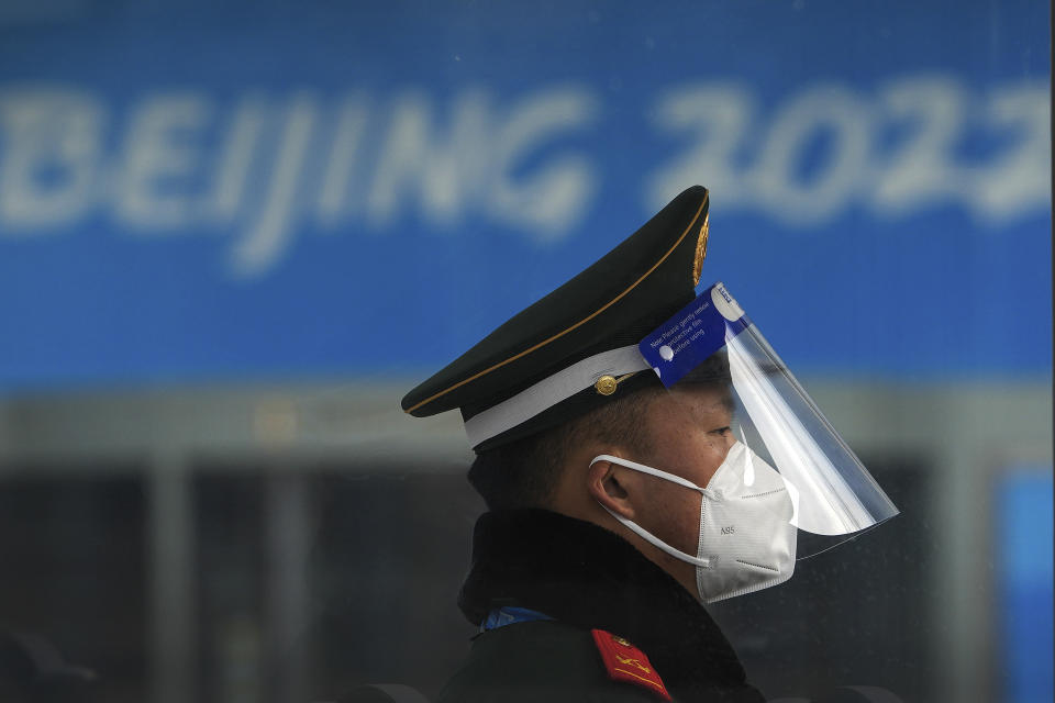 A Chinese paramilitary policeman wearing a face shield and mask to protect from the coronavirus stands guard at an entrance gate to a barricaded Main Press Center (MPC) for the Winter Olympic Games in Beijing, Wednesday, Jan. 19, 2022. China has locked down parts of Beijing's Haidian district following the detection of three cases, just weeks before the capital is to host the Winter Olympic Games. (AP Photo/Andy Wong)