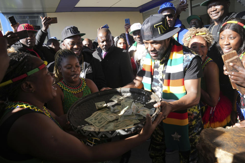 U.S boxing promoter and former professional boxer Floyd Joy Mayweather holds a reed basket with cash upon arrival at Robert Mugabe airport in Harare, Zimbabwe, Thursday, July 13 2023. Mayweather is in the country for what he is calling the Motherland Tour. (AP Photo/Tsvangirayi Mukwazhi)