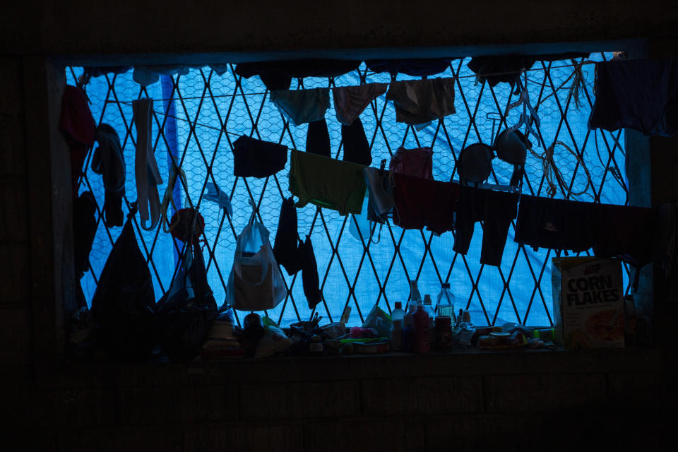 Clothes hang dry inside a warehouse where a family left homeless by last year's hurricanes Eta and Iota live near the Chamelecon neighborhood of San Pedro Sula, Honduras, Tuesday, Jan. 12, 2021. The devastation wrought by November's hurricanes and the economic damage of the COVID-19 pandemic has added to the forces of poverty and gang violence that drive Hondurans to migrate. (AP Photo/Moises Castillo)