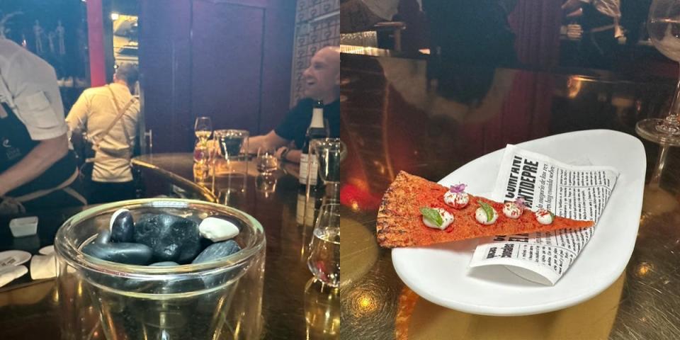 rock-shaped food on a plate next to photo of a faux piece of pizza on a fake newspaper at restaurant