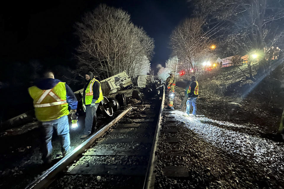 In this image provided by New York State Department of Environmental Conservation, train crews and first responders walk the site of a train derailment, Wednesday evening, Feb. 7, 2024, in Valley Falls, N.Y. Authorities say 10 cars of a 94-car cargo train carrying plastic pellets and cooking oil, derailed in upstate New York, with two ending up in a river. (Basil Seggos/ New York State Department of Environmental Conservation via AP)