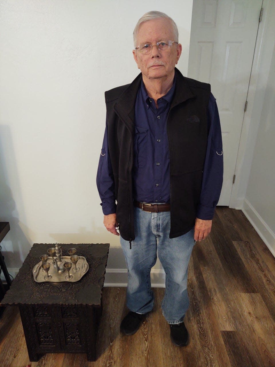 John Foster standing next standing next to the table his grandparents used to store historical items such as a pre-WWI photograph album and the diary of abolitionist John Swaim. The Swaim diary led Foster to write  three books, and a series of journal articles in the Florida Historical Quarterly about Reconstruction Florida.