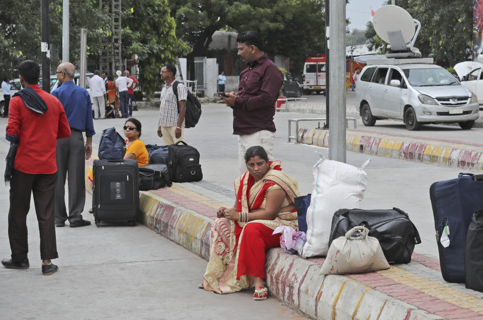 Passengers wait for transportation during a public transport strike in New Delhi, India, Thursday, Sept. 19, 2019. Commuters in the Indian capital are facing problems as a large section of the public transport, including private buses, auto-rickshaws and a section of app-based cabs Thursday remained off the roads in protest against a sharp increase in traffic fines imposed by the government under a new law.(AP Photo/Manish Swarup)