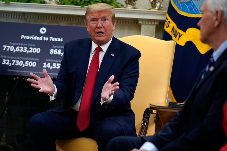 President Donald Trump speaks as Vice President Mike Pence listens at right during a meeting about the coronavirus response in the Oval Office.