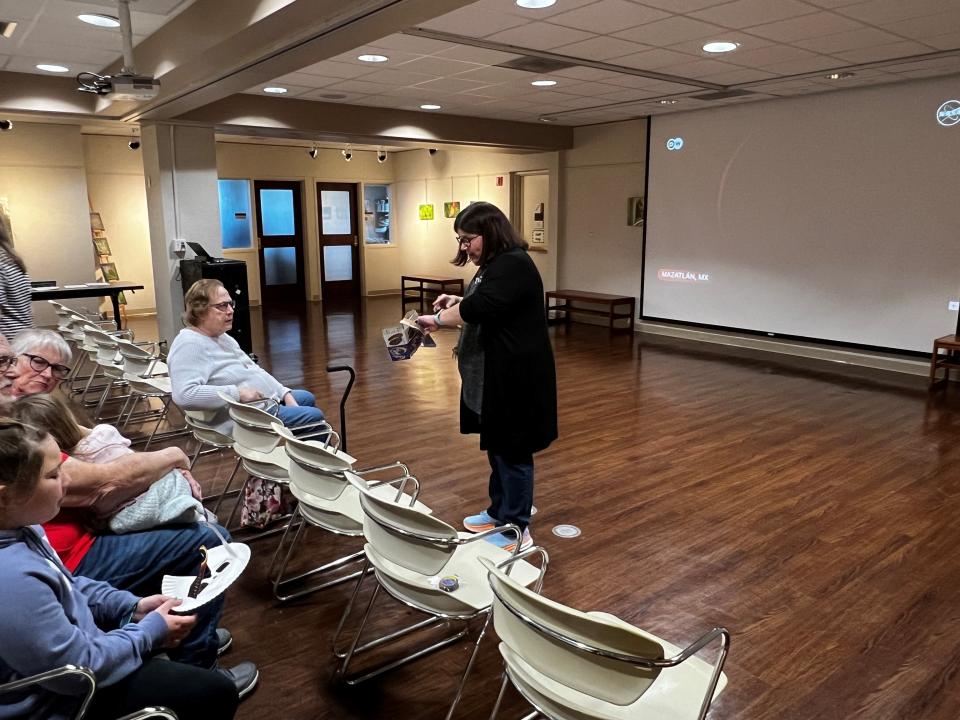 Fairfield County District Library Director Becky Schaade talks to those at the library's solar eclipse watch party on Monday, April 8, 2024. People could watch the event live outside or inside on a large screen showing NASA's live stream.