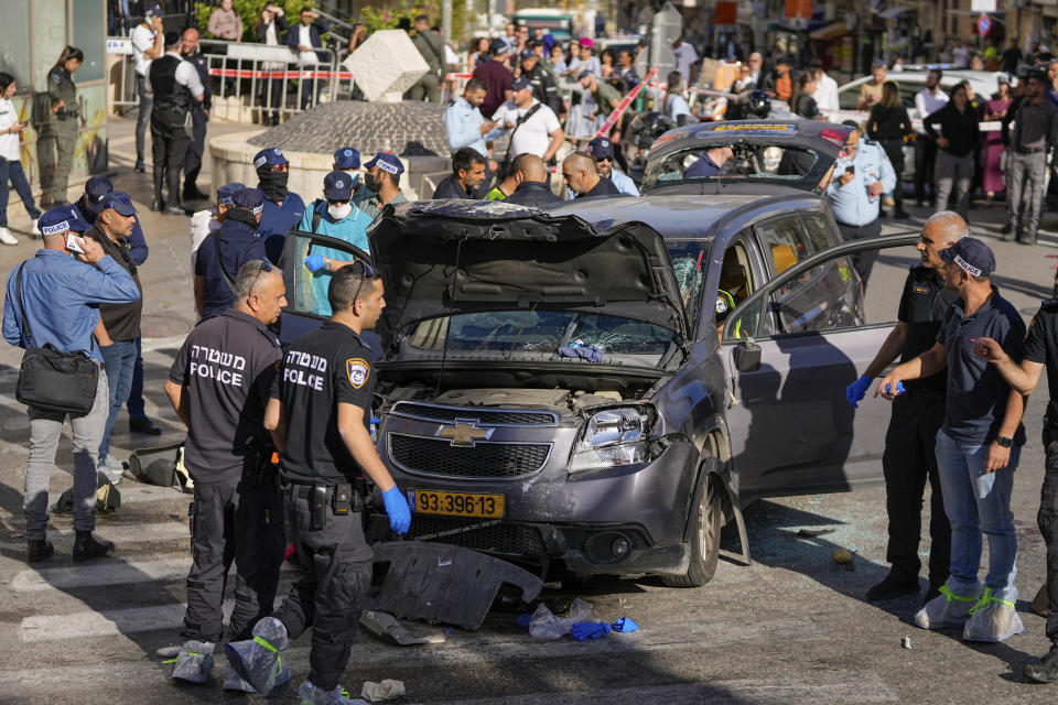 Israeli police examine the scene of a car ramming attack, in Jerusalem, Monday, April 24, 2023. Israeli Prime Minister Benjamin Netanyahu says multiple people have been attacked and wounded near a popular market in Jerusalem. (AP Photo/Ohad Zwigenberg)