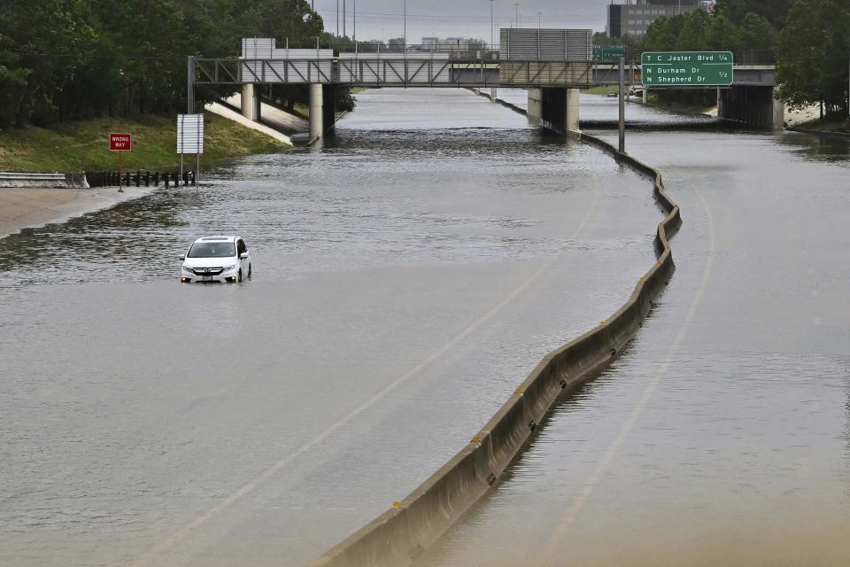 A vehicle is stranded in high waters on a flooded highway in Houston, July 8, 2024, after Beryl came ashore. (AP Photo/Maria Lysaker)