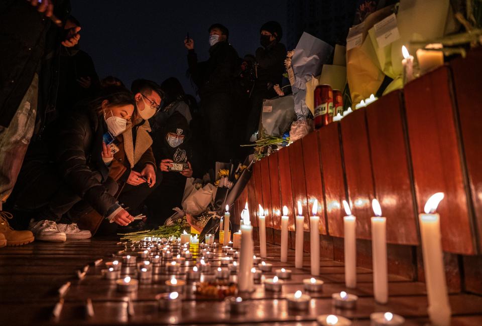 Protesters light candles and leave cigarettes at a memorial during a protest against China's strict zero COVID-19 measures on Nov. 27 in Beijing.