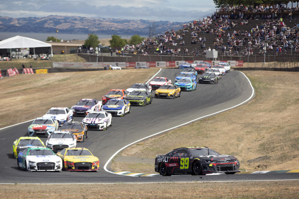 Eventual winner Daniel Suarez (99) leads the pack through Turn 3 during a NASCAR Cup Series auto race, Sunday, June 12, 2022, at Sonoma Raceway in Sonoma, Calif. (AP Photo/D. Ross Cameron)