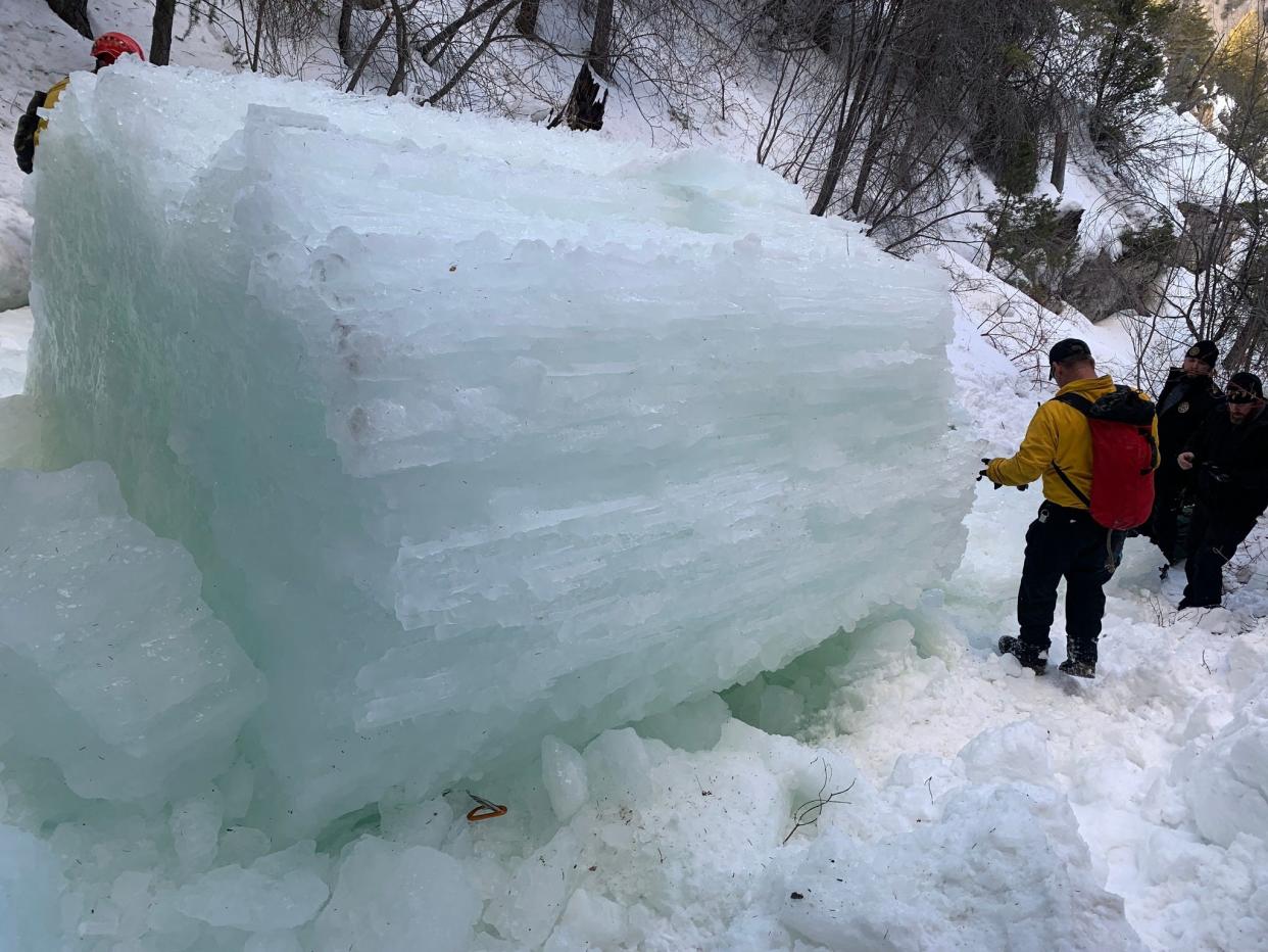 image if ice column on mountain with worker nearby