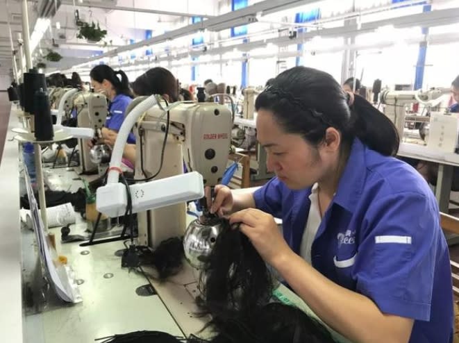 假髮工廠員工正在用機器製作假髮。 圖 : 翻攝自財經網