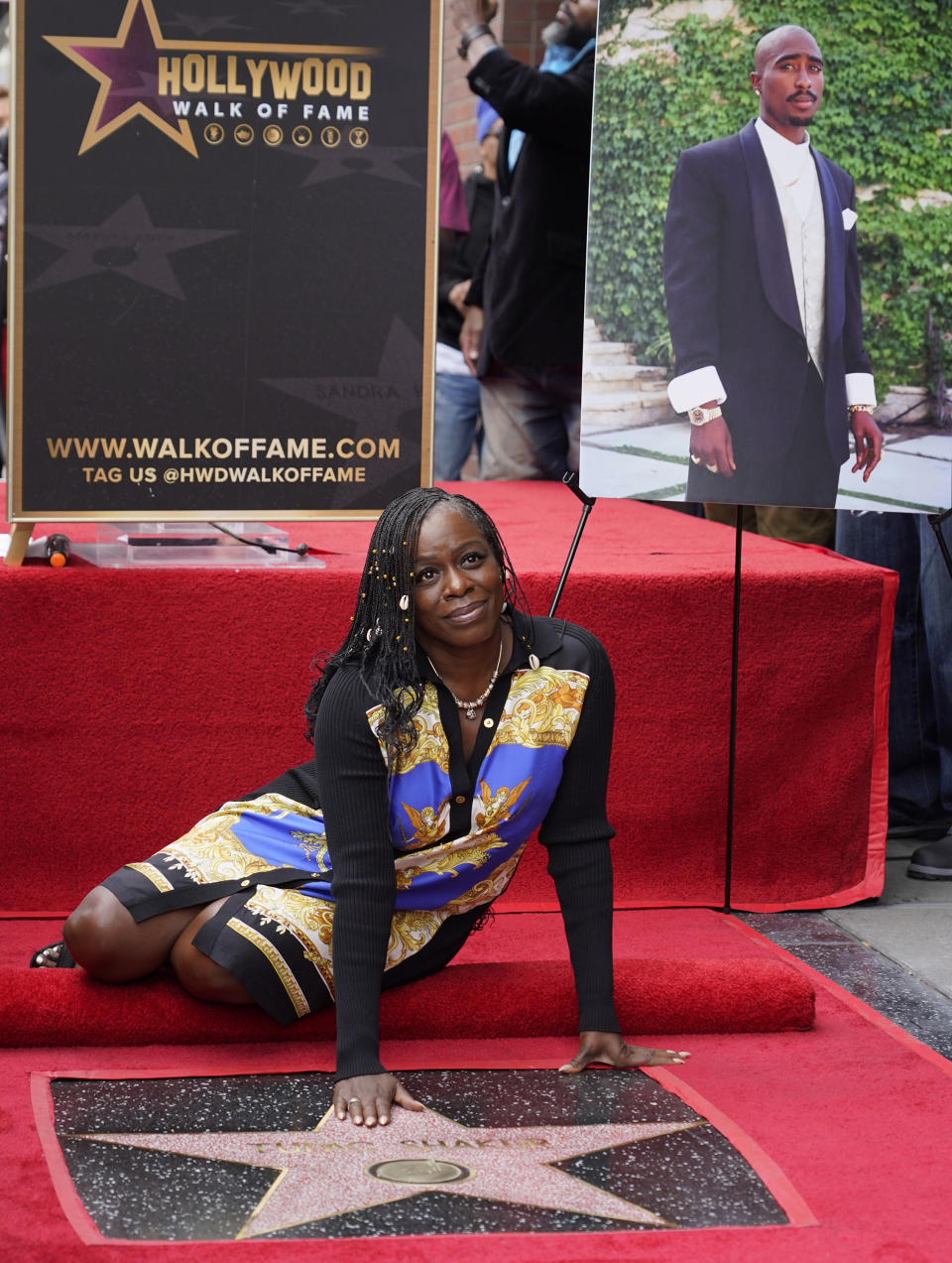 Sekyiwa "Set" Shakur poses atop her late brother Tupac Shakur's star on the Hollywood Walk of Fame during a posthumous ceremony in his honor on Wednesday, June 7, 2023, in Los Angeles. The late rapper and actor is pictured at right. (AP Photo/Chris Pizzello)