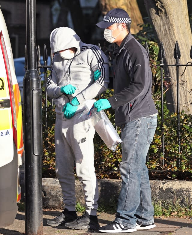 Police officers take a suspect away during a raid at an address in Islington, north London