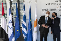 Cyprus' foreign minister Nicos Christodoulides, right, talks with his Greek counterpart Nikos Dendias before a meeting of the ministers of foreign affairs of Cyprus, Greece, Israel and United Arab of Emirates in city of Paphos, Cyprus, Friday, April 16, 2021. The event marks the first time the foreign ministers of all four countries have met following the recent normalization of relations between Israel and the United Arab Emirates and aims to expand cooperation to bolster regional stability. (Iakovos Hatzistavrou/Pool via AP)