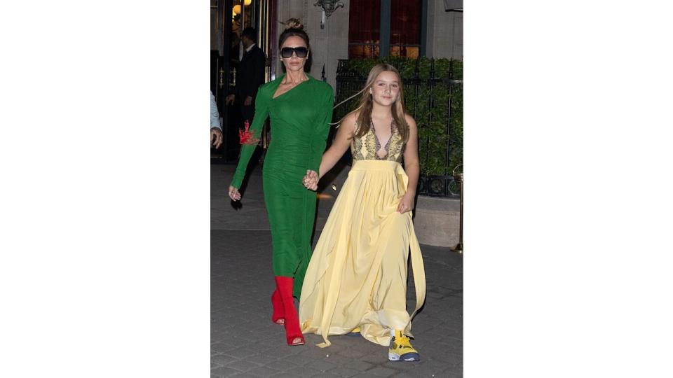 Victoria Beckham in a green dress and Harper Beckham in a yellow dress