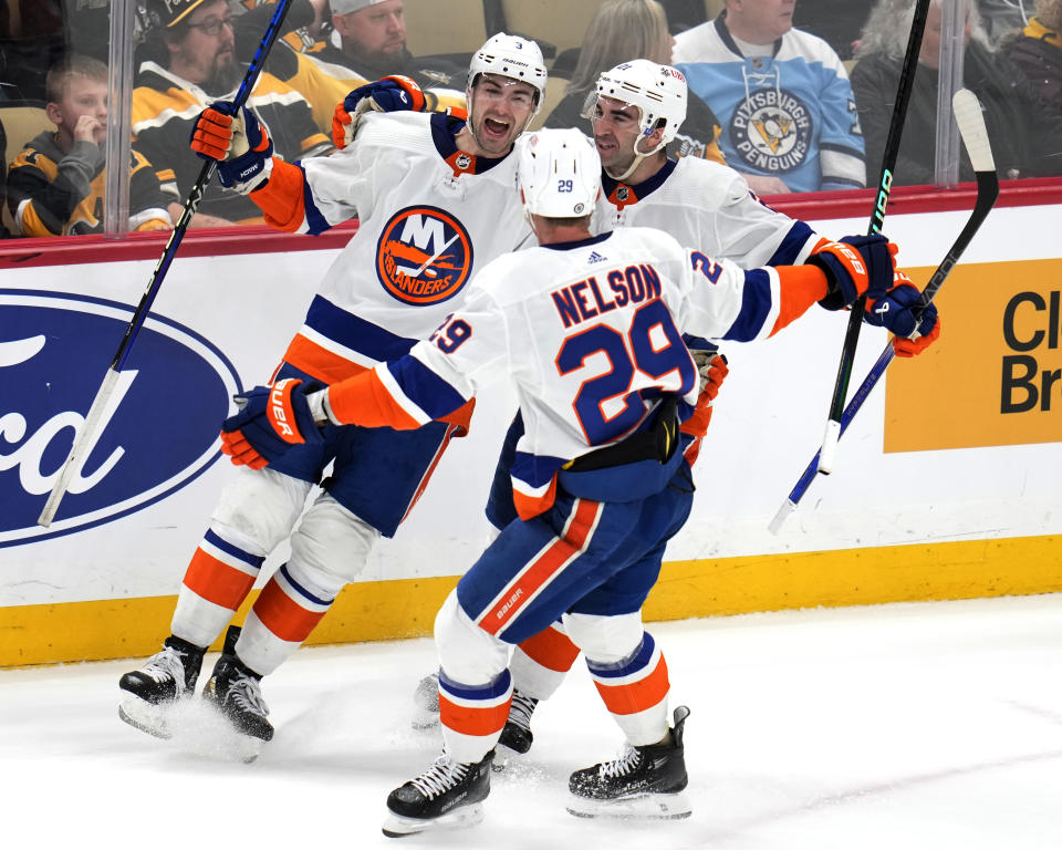 New York Islanders' Adam Pelech (3) celebrates his game-winning goal in overtime with Kyle Palmieri (21) and Brock Nelson during an NHL hockey game in Pittsburgh, Tuesday, Feb. 20, 2024. The Islanders won 5-4. (AP Photo/Gene J. Puskar)