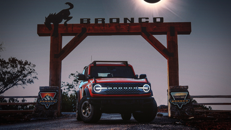 Ford Bronco SUV in front of Bronco sign