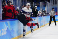 United States' Kenny Agostino (11) checks Canada's Eric Staal into the bench area during a preliminary round men's hockey game at the 2022 Winter Olympics, Saturday, Feb. 12, 2022, in Beijing. (AP Photo/Matt Slocum)