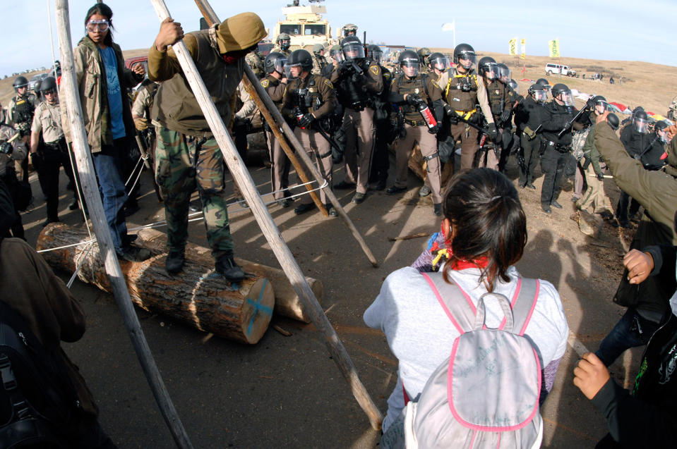 <p>Protesters in the left foreground shield their faces as a line of law enforcement officers holding large canisters with pepper spray shout orders to move back during a standoff in Morton County, N.D., Thursday, Oct. 27, 2016. (Photo: Mike McCleary/The Bismarck Tribune via AP) </p>