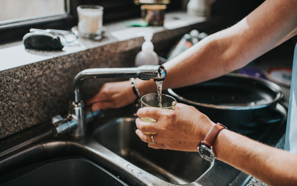 someone filling up a glass of water