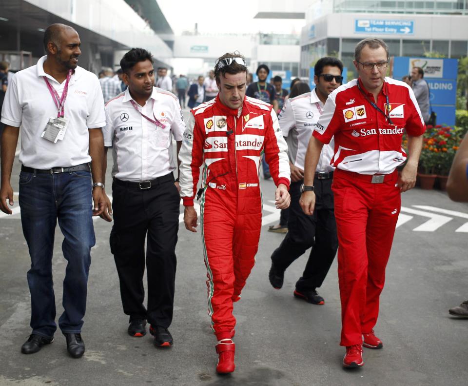 Ferrari Formula One driver Fernando Alonso of Spain (C) walks with Team Principal Stefano Domenicali (R) during the Indian F1 Grand Prix at the Buddh International Circuit in Greater Noida, on the outskirts of New Delhi, October 25, 2013. REUTERS/Anindito Mukherjee (INDIA - Tags: SPORT MOTORSPORT F1)