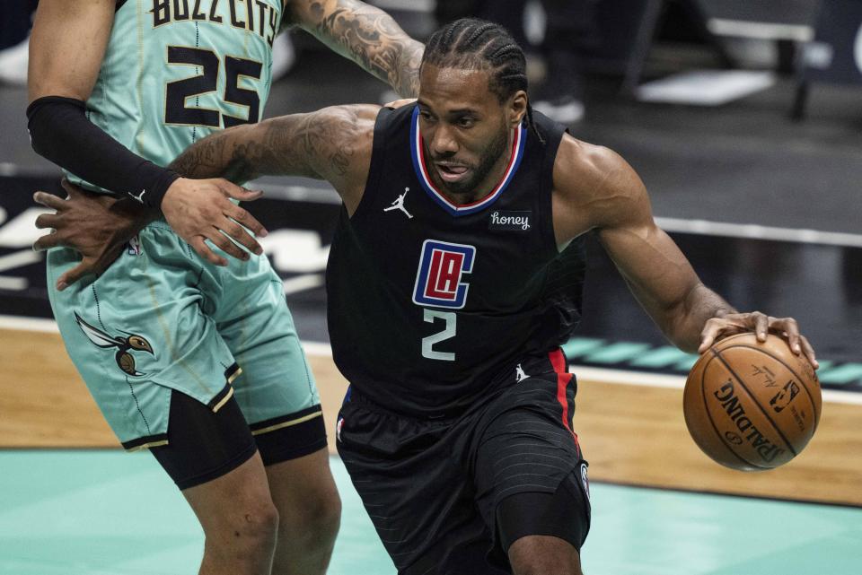 Los Angeles Clippers forward Kawhi Leonard (2) dribbles past Charlotte Hornets forward P.J. Washington (25) during the first half of an NBA basketball game in Charlotte, N.C., Thursday, May 13, 2021. (AP Photo/Jacob Kupferman)