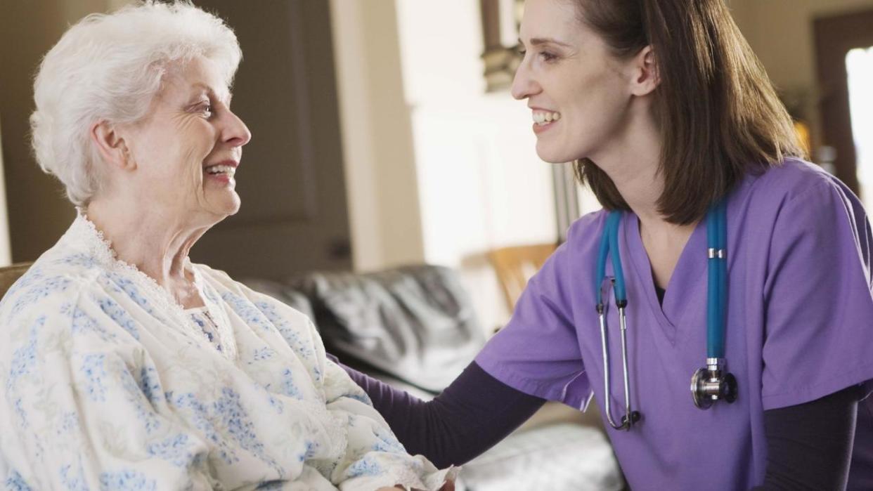 Nurse smiling with patient at home - generic aged care
