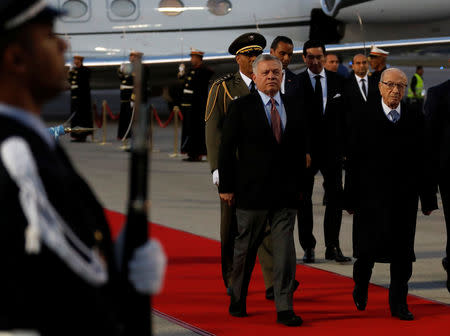 King Abdullah II of Jordan, left, walks next to Tunisian President Beji Caid Essebsi, as they review an honor guard, upon his arrival at Tunis-Carthage international airport to attend the Arab Summit, in Tunis, Tunisia March 30, 2019. Hussein Malla/Pool via REUTERS