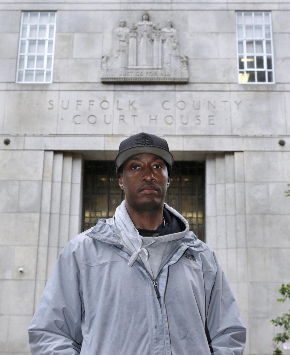 In this June 13, 2019 photo, Sean Ellis poses for a photo outside the Suffolk County Superior Court House in Boston. During the 22 years he spent in prison after being convicted of killing a Boston police detective, Ellis believed there was something suspicious about the officers who led the murder investigation. He just couldn’t prove it. It would take years of digging and scores of public information requests from his attorneys to uncover evidence that several officers investigating the 1993 murder case were involved in criminal activity, information that wasn’t shared with the defense. (AP Photo/Charles Krupa)