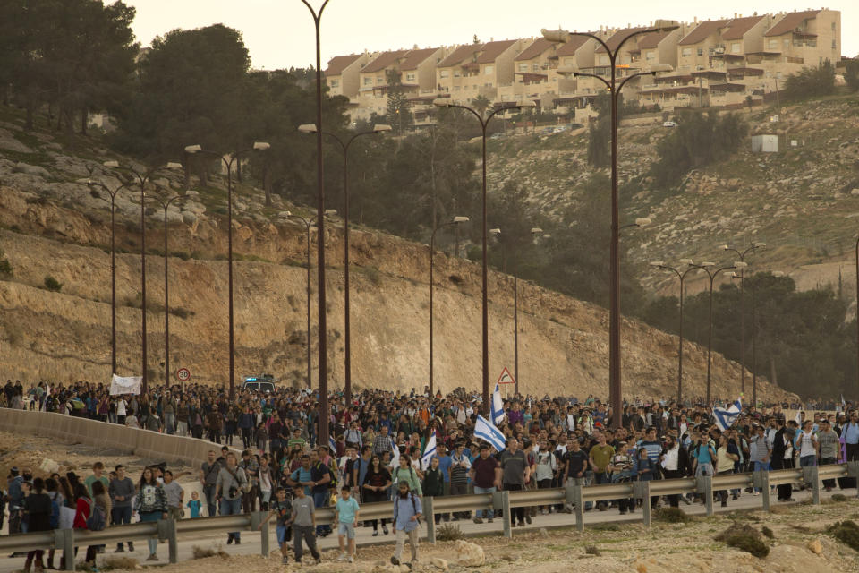 Israelis march from the West Bank settlement of Maaleh Adumim to the E-1 area on the eastern outskirts of Jerusalem, Thursday, Feb. 13, 2014. Israel planned construction in the area E-1, or East 1, but froze under the international pressure in 2009. The construction in the area would effectively separate Palestinians in east Jerusalem from the West Bank. (AP Photo/Sebastian Scheiner)