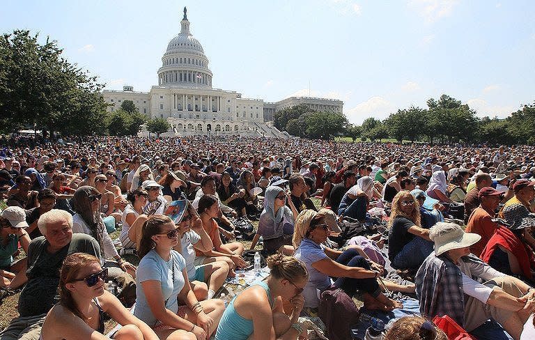 People are seen gathering on the grounds of the US Capitol to listen to the Dalai Lama delivering a talk for world peace, on July 9, in Washington, DC. Tibet's exiled spiritual leader enjoys wide global popularity, speaking to arenas full of thousands of people. But he is demonized by China, which has called him a "wolf in monk's clothing."