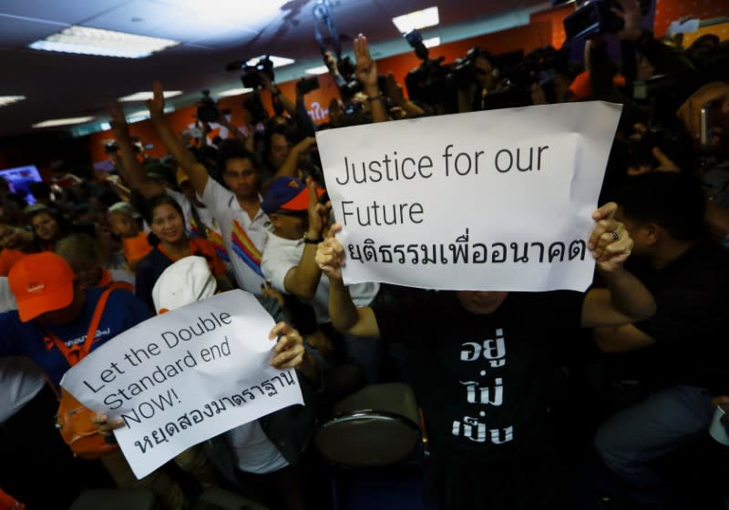 Supporters of Future Forward Party react with signs after Thailand's Constitutional Court ruled that key figures of the opposition Future Forward Party were not guilty of opposing the monarchy, at the party's headquarters in Bangkok