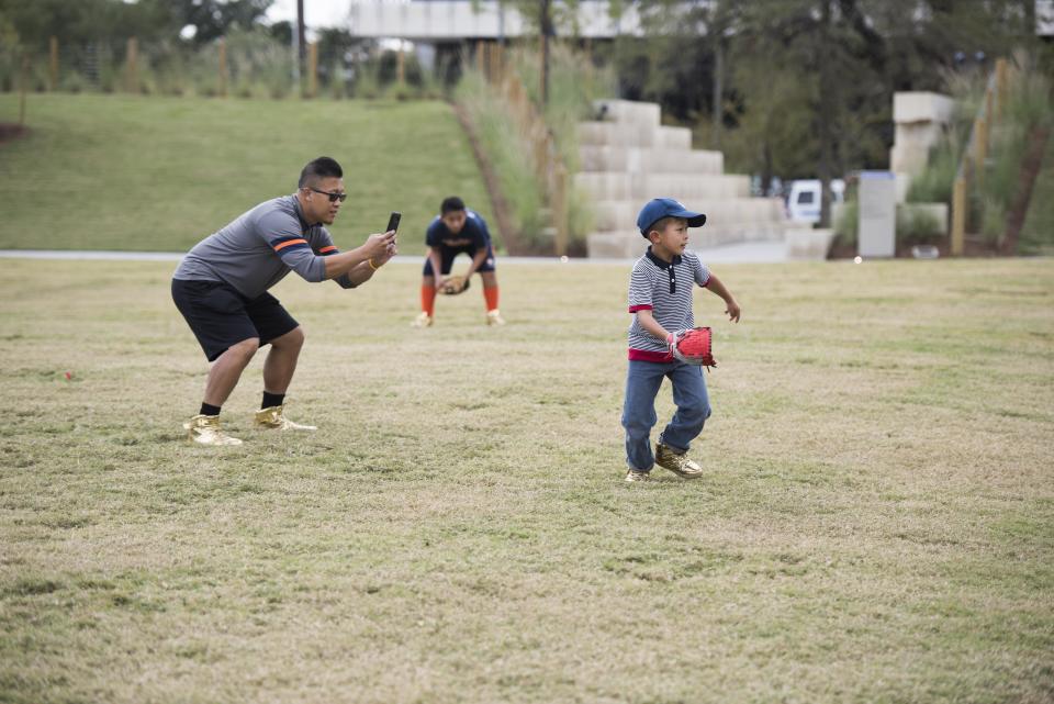 David Vuong and his sons Augustine-Pio, Alphonsus-Leo and Hyacinth-Michael&nbsp;play a game of baseball at Midtown Park in Houston.