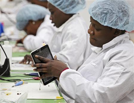 Workers assemble Android-based tablets from imported components at the Surtab factory in the Sonapi Industrial Park of Port-au-Prince March 11, 2014. REUTERS/Marie Arago