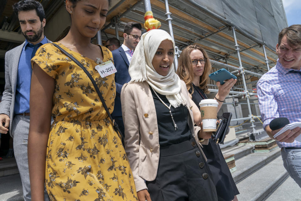 Rep. Ilhan Omar, D-Minn., a target of racist rhetoric from President Donald Trump, walks from the House to her office surrounded by reporters, at the Capitol in Washington, Thursday, July 18, 2019. (AP Photo/J. Scott Applewhite)