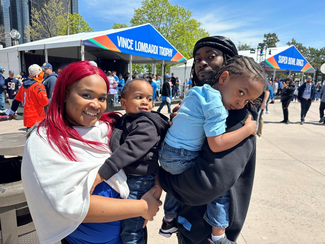 Shelby Smith, 26, holds son Kasaan Balantine, 2, next to her son Kainan Balantine, 3, held by father Kordrey Balantine, 36, inside Hart Plaza's NFL Draft Experience on Friday, April 26, 2024.