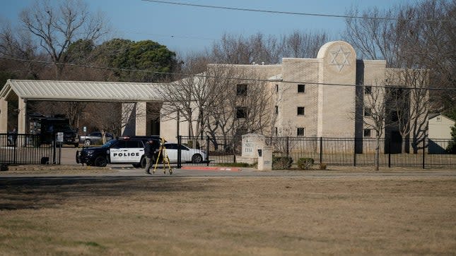 Law enforcement process the scene in front of the Congregation Beth Israel synagogue