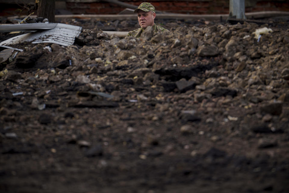 A Ukrainian serviceman pauses while retrieving items from an impact crater at the site of a Russian attack in Kyiv, Ukraine, Thursday, March 21, 2024. Around 30 cruise and ballistic missiles were shot down over Kyiv on Thursday morning, said Serhii Popko, the head of Kyiv City Administration. The missiles were entering Kyiv simultaneously from various directions in a first missile attack on the capital in six weeks. (AP Photo/Vadim Ghirda)