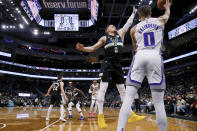 Milwaukee Bucks guard Donte DiVincenzo (0) defends against a pass by Sacramento Kings guard Tyrese Haliburton (0) during the first half of an NBA basketball game Saturday, Jan. 22, 2022, in Milwaukee. (AP Photo/Jon Durr)