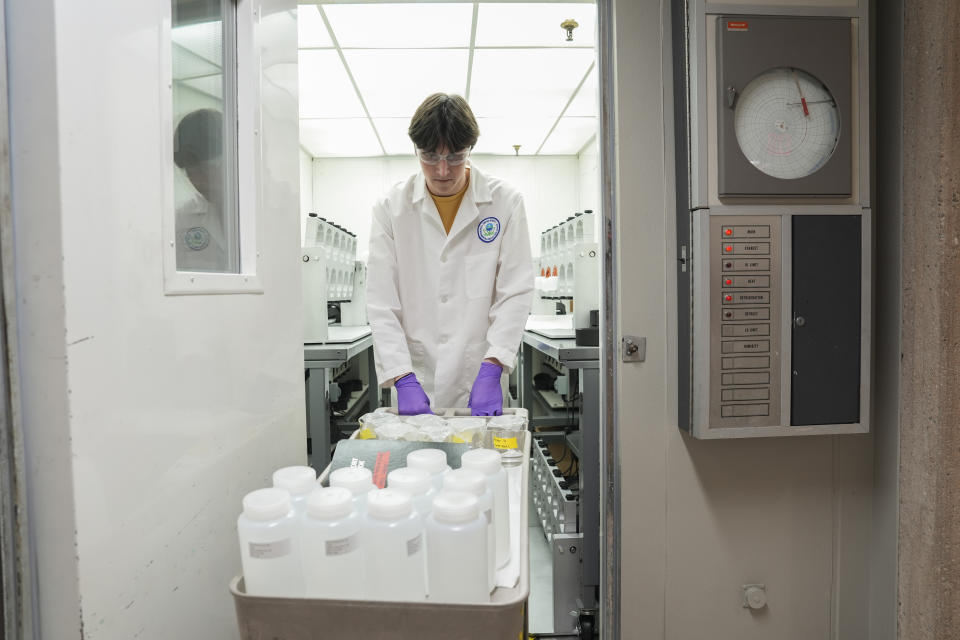 Jackson Quinn brings PFAS water samples into a temperature controlled room, Wednesday, April 10, 2024, at a U.S. Environmental Protection Agency lab in Cincinnati. The Environmental Protection Agency on Wednesday announced its first-ever limits for several common types of PFAS, the so-called "forever chemicals," in drinking water.(AP Photo/Joshua A. Bickel)