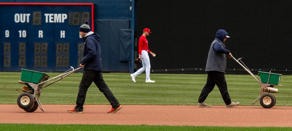 Polar Park grounds crew workers add material to the infield as WooSox players begin to warm up on the first day of practice Tuesday.