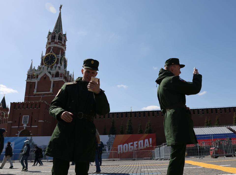 Russian military officers look at their smartphones while walking past the Kremlin in Moscow on April 24.