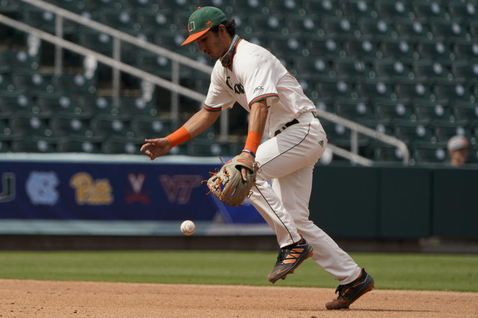 Miami shortstop Dominic Pitelli can't get a glove on a ball hit by Florida State's Logan Lacey in the third inning of an NCAA college baseball game at the Atlantic Coast Conference tournament on Friday, May 28, 2021, in Charlotte, N.C. (AP Photo/Chris Carlson)